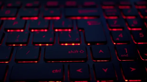 A close-up of a keyboard with red light glowing from under the keys