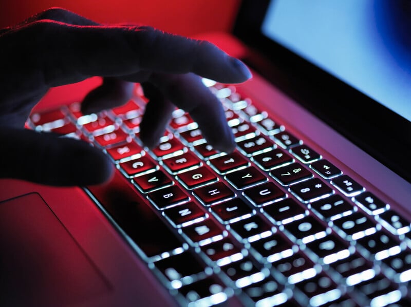 Hand auf rot beleuchteter Tastatur