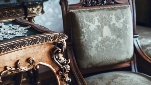 A vintage wooden table and upholstered mahogany chair
