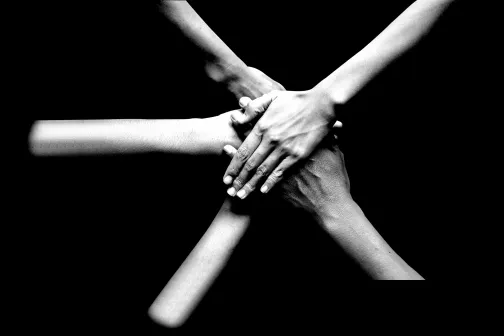 group of people putting hands together - teamwork - contacto DUAL Iberica