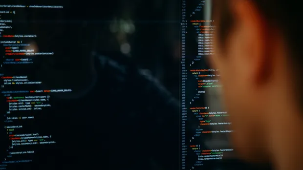 A man looking at code on a computer screen