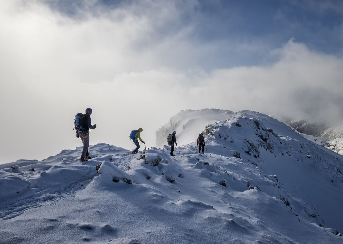 Group of mountaineers ascending a snowy and rock mountain range